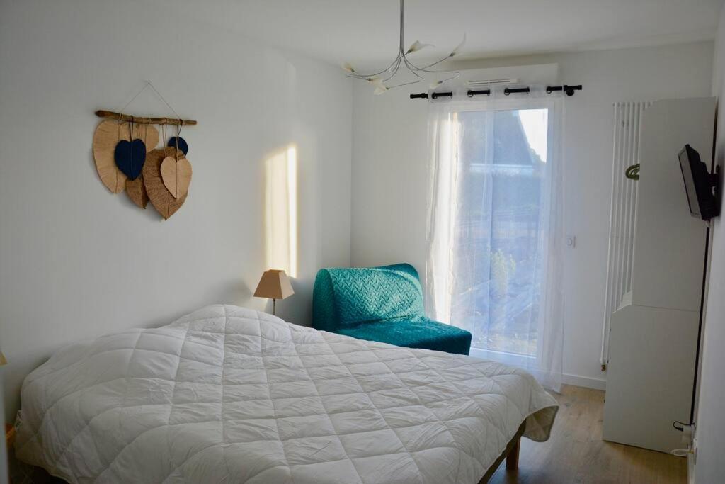 a bedroom with a bed and a blue chair at TY DOLMEN DU Plages à pied 2 vélos WIFI in Carnac