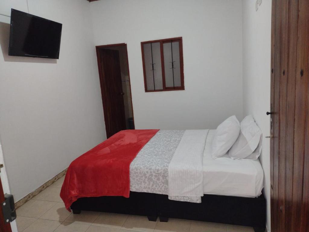 una camera con un letto con una coperta rossa e bianca di Hotel Lili Popayán - Sede 2 a Popayan