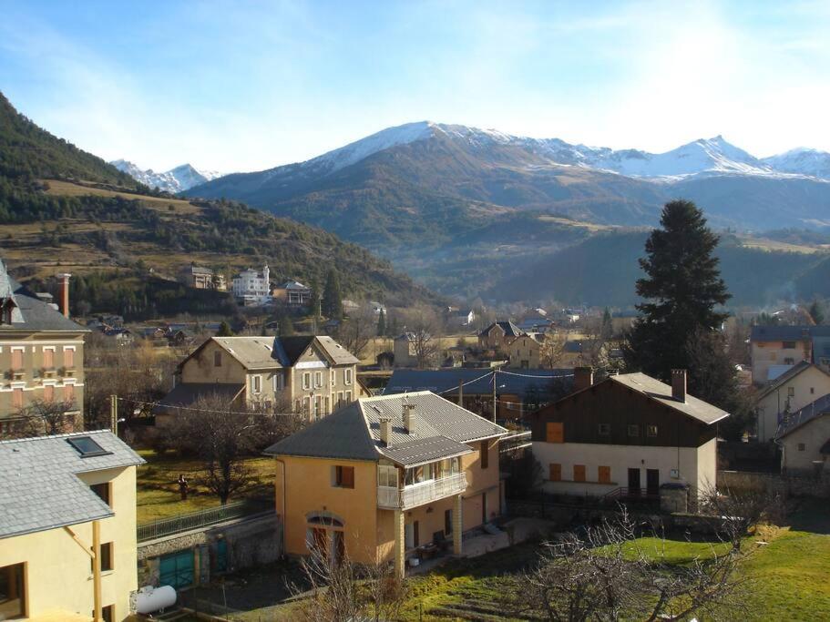 miasto z domami i górami w tle w obiekcie Appart T3 de charme sous les toits Jausiers 6 pers w mieście Jausiers