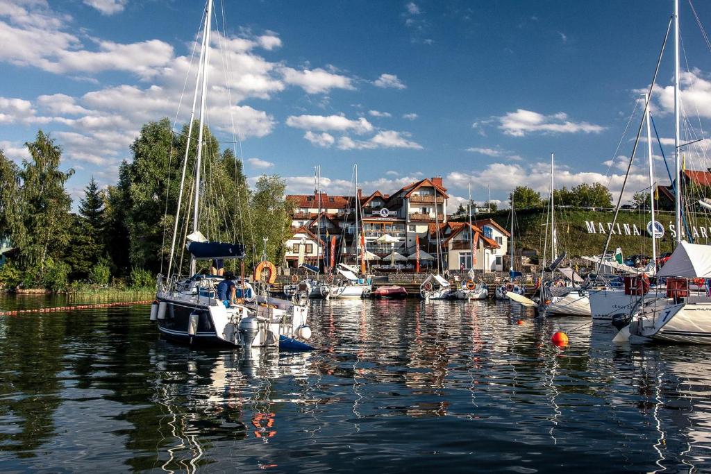 a group of boats are docked in a harbor at Marina Śniardwy Resort in Nowe Guty