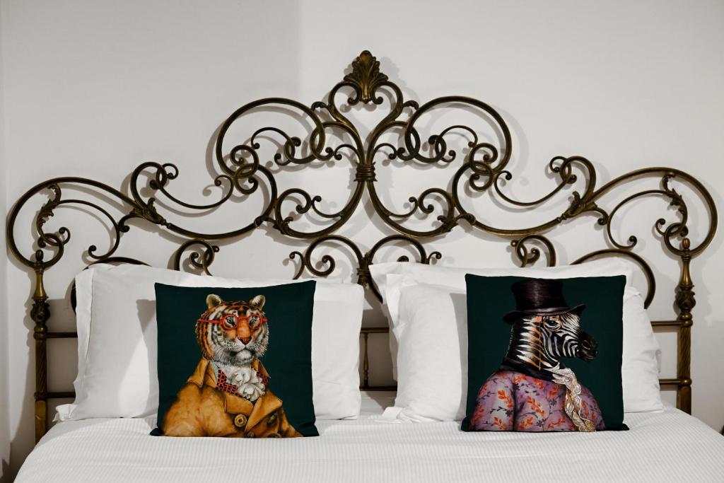 a bed with a metal headboard with a stuffed tiger and a zebra at Vicolo 22 - Residenze Romanae in Rome