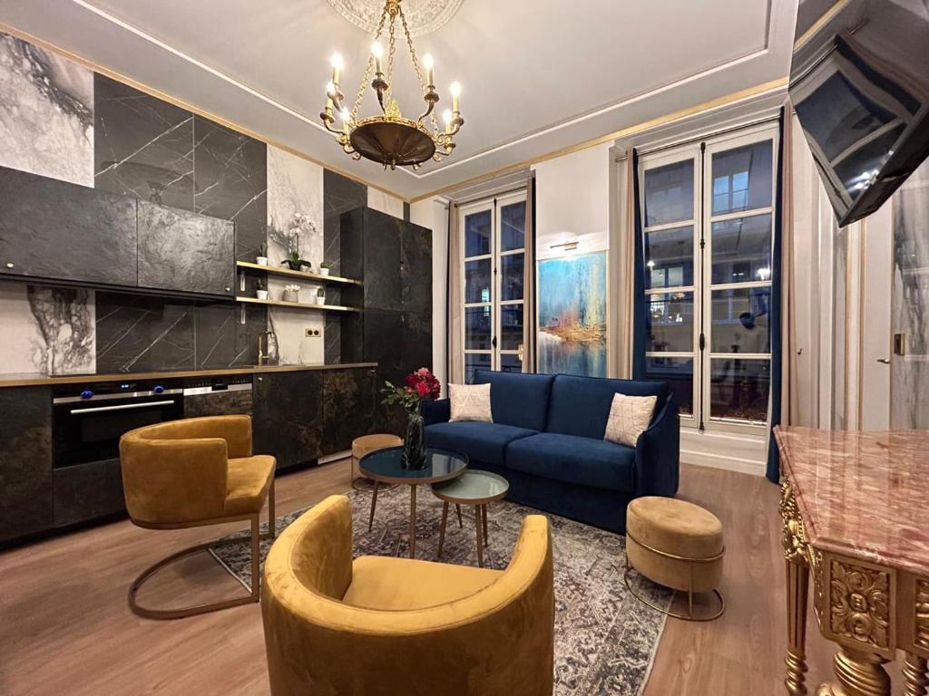 sala de estar con sofá azul y sillas en Luxury 3 bedroom 2 bathroom apartment - Louvre, en París