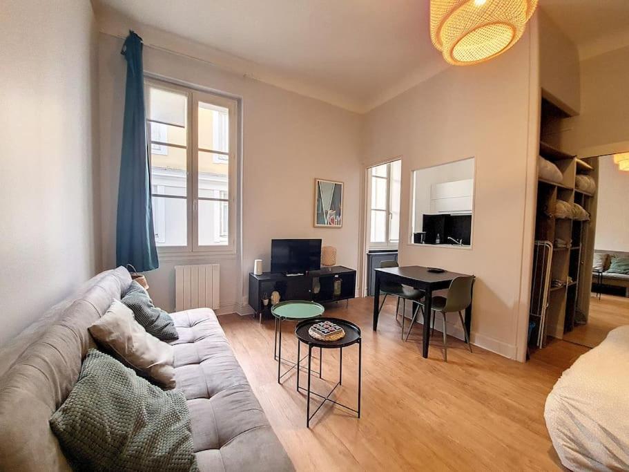 sala de estar con sofá y mesa en Magnifique Appartement - Hôtel du Parc - VICHY, en Vichy