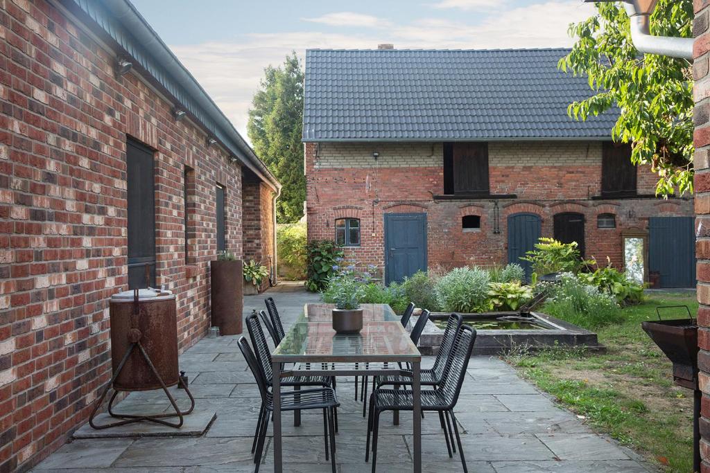 a patio with a table and chairs and a brick building at Alte Flachsfarm in Cottbus
