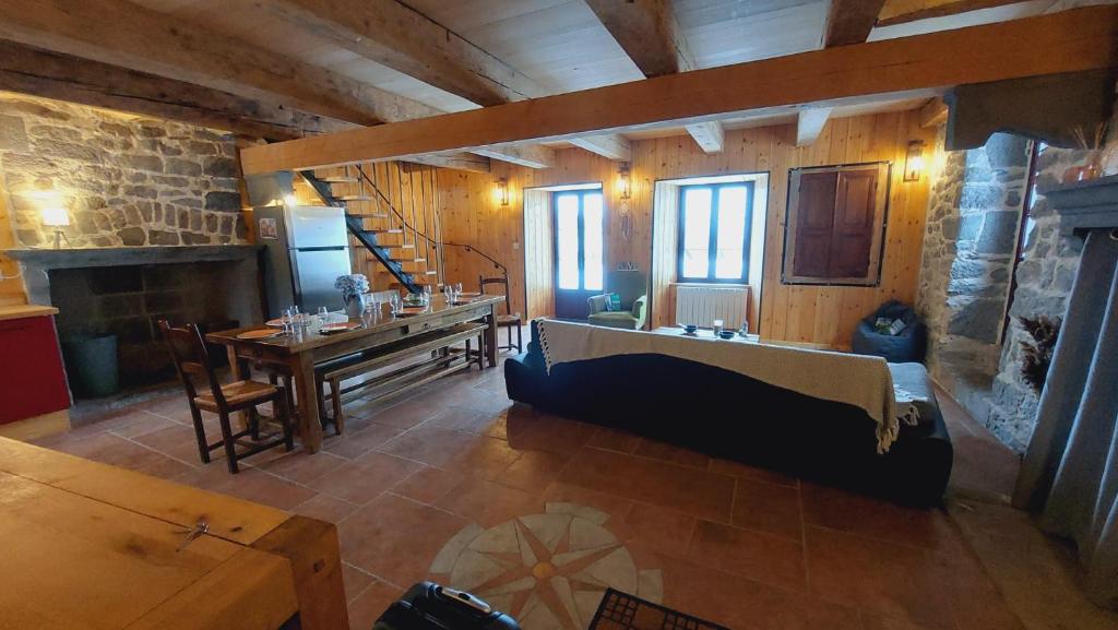 Cette grande chambre dispose d'une table et d'une cheminée. dans l'établissement Chez Maritou, à Besse-et-Saint-Anastaise