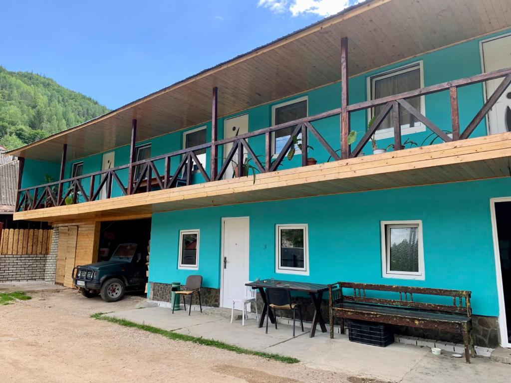 ein blaues Gebäude mit einem Tisch und einem Balkon in der Unterkunft Acasa in Bicaz-Chei - Camere de inchiriat Cheile Bicazului in Bicaz-Chei