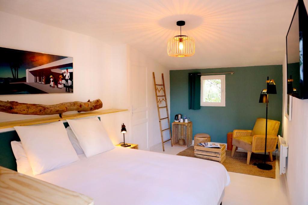 a bedroom with a white bed and a living room at Relais de Chasse la Chaignaie in Montaigu-Vendée