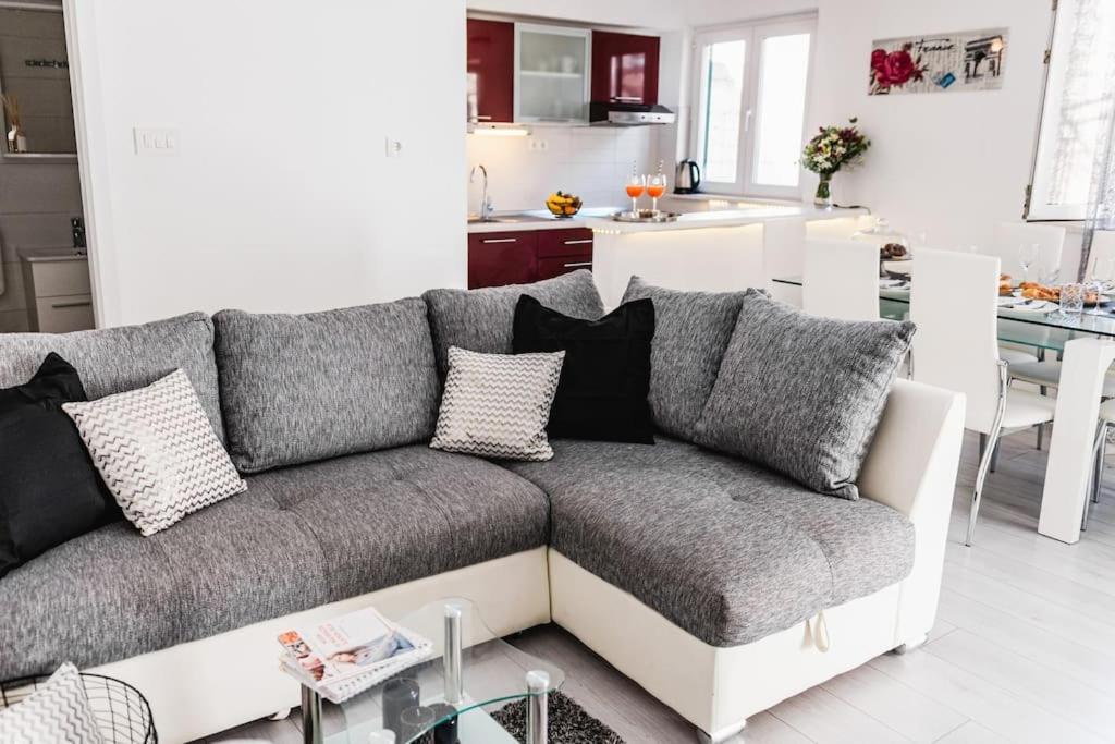 a living room with a couch and a kitchen at Holiday home Marina-renovated house in city center in Rogoznica
