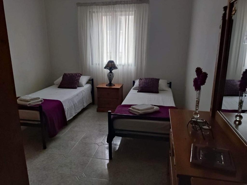 1 dormitorio con 2 camas, tocador y espejo en St Julian's Twin Room In A Private House, en San Julián