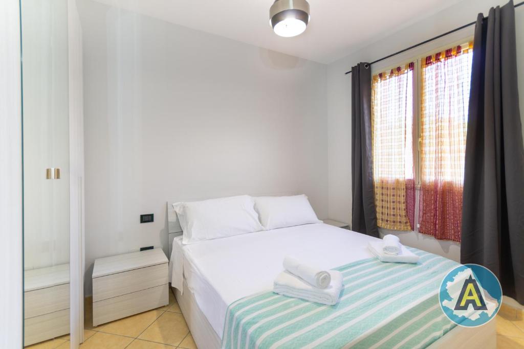 a white bedroom with a bed and a window at Comodo a due passi dal mare 46a in Silvi Paese