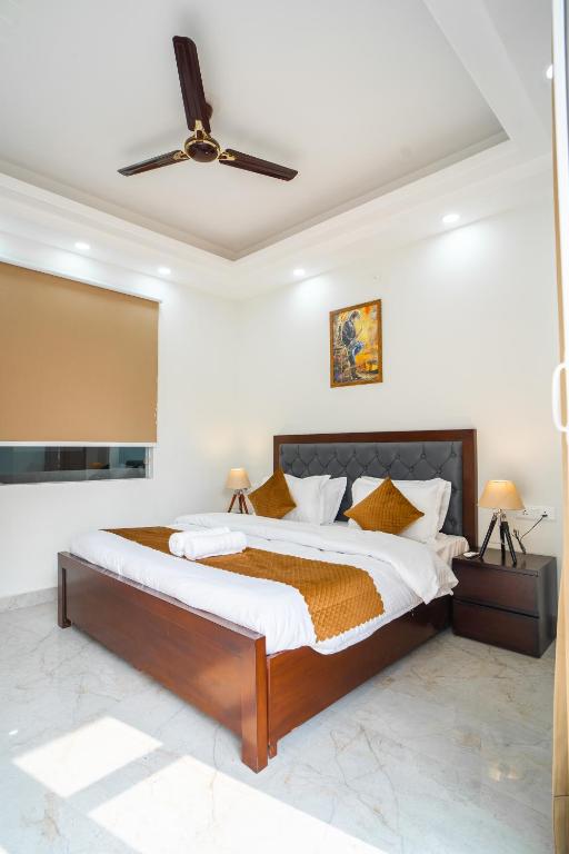a bedroom with a large bed with a ceiling fan at The Lodgers 1 BHK Serviced Apartment Golf Course Road Gurgaon in Gurgaon
