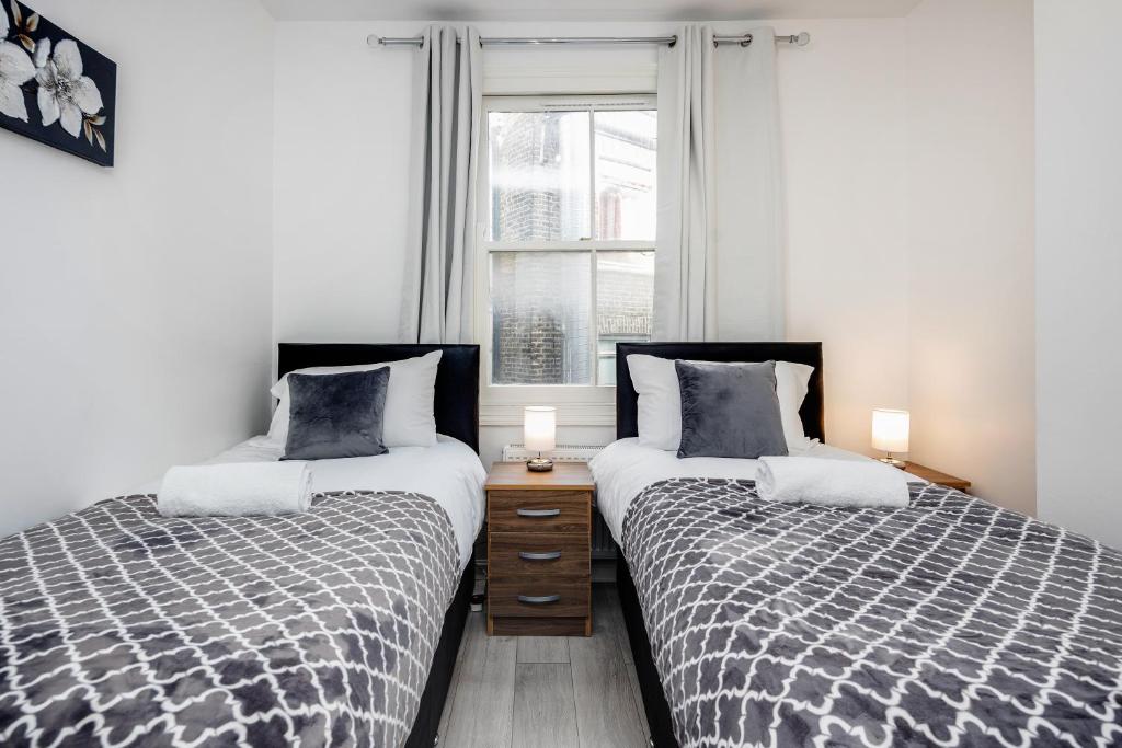 two beds sitting next to each other in a bedroom at CONEN Chert Apartment in London