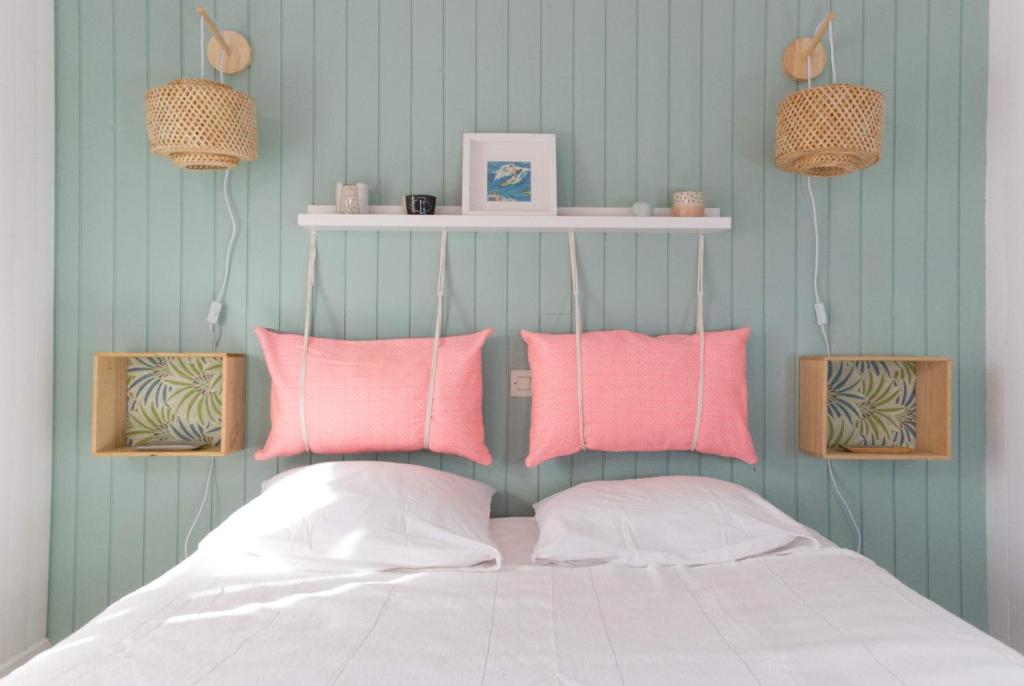 a bedroom with pink and white pillows on a bed at La Mariennée in La Rochelle