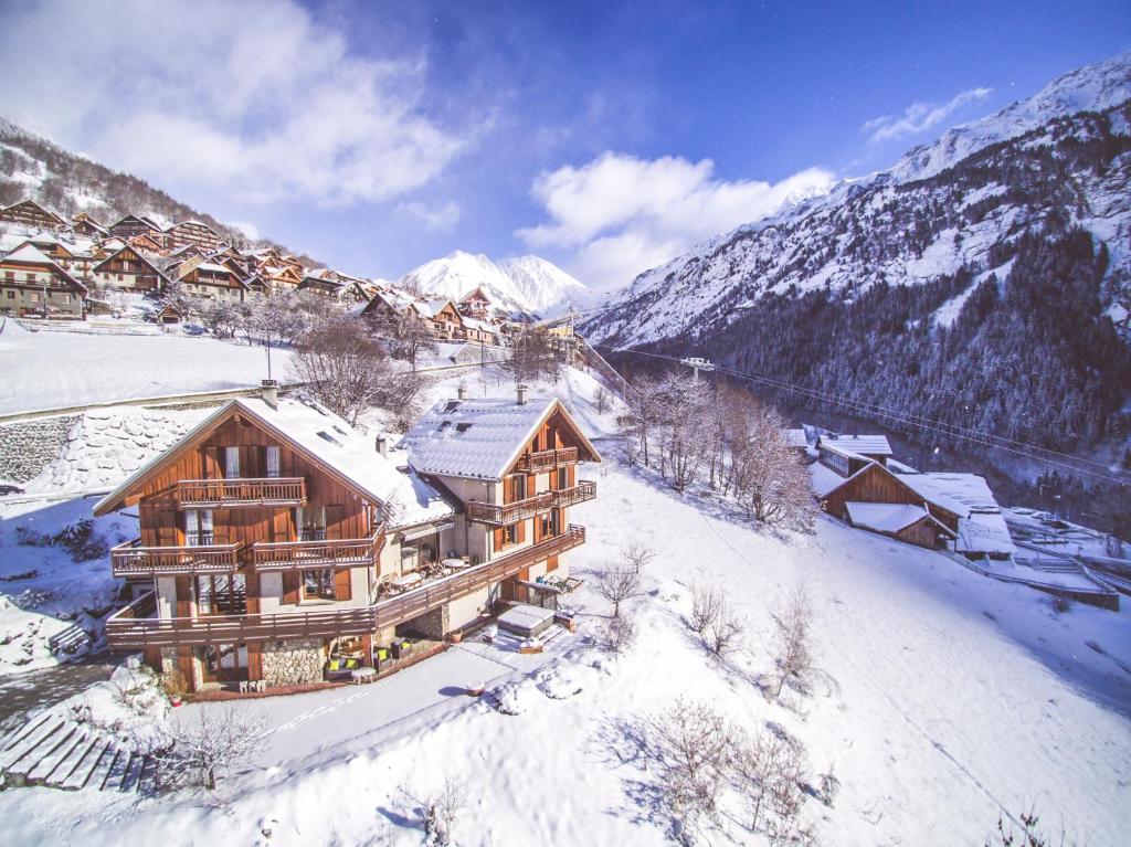 a log cabin in the snow with mountains at Chalet Saskia - Simply Perfect in Vaujany