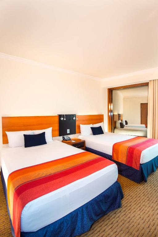 Postel nebo postele na pokoji v ubytování Hotel Guadalajara Plaza Expo