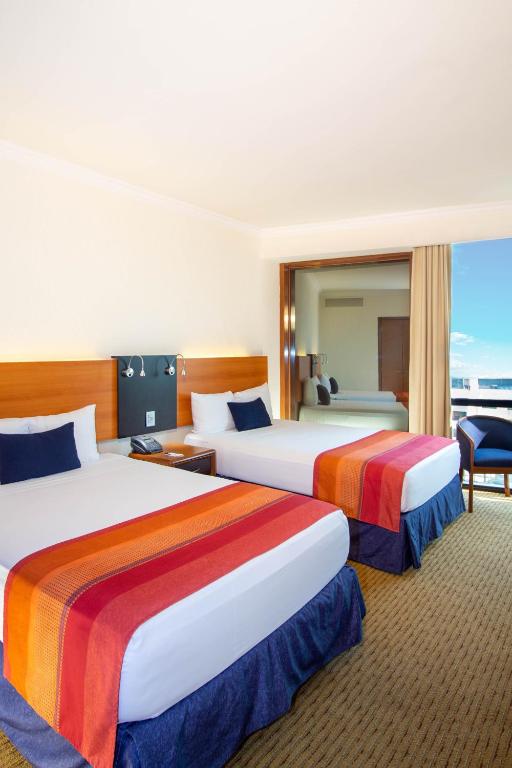 Postel nebo postele na pokoji v ubytování Hotel Guadalajara Plaza Expo