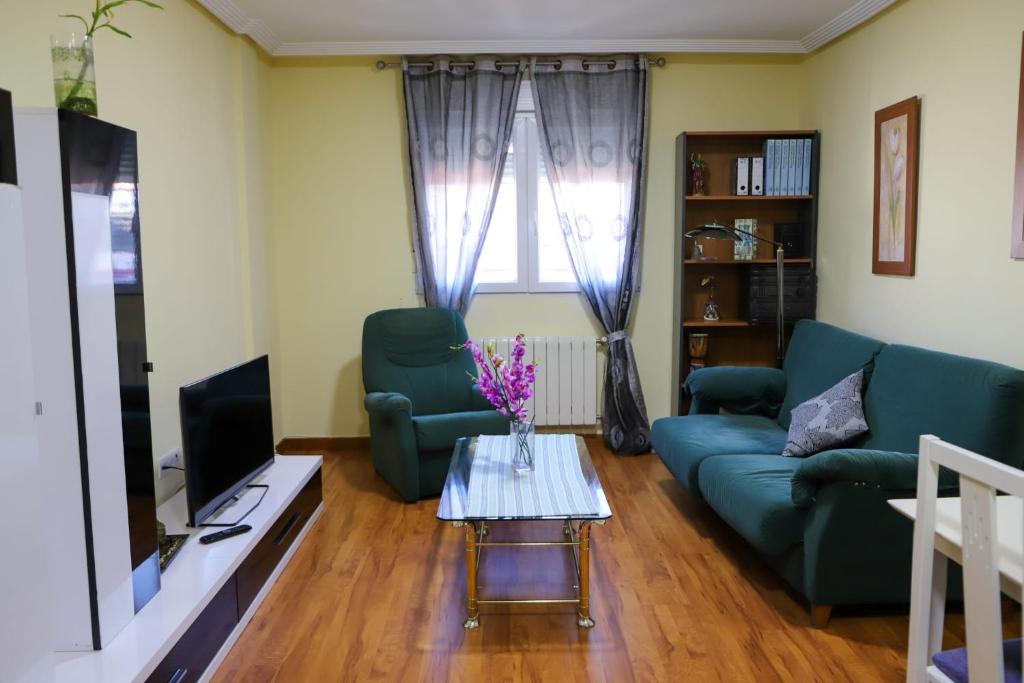 sala de estar con sofá azul y TV en Casa MJ, en Béjar