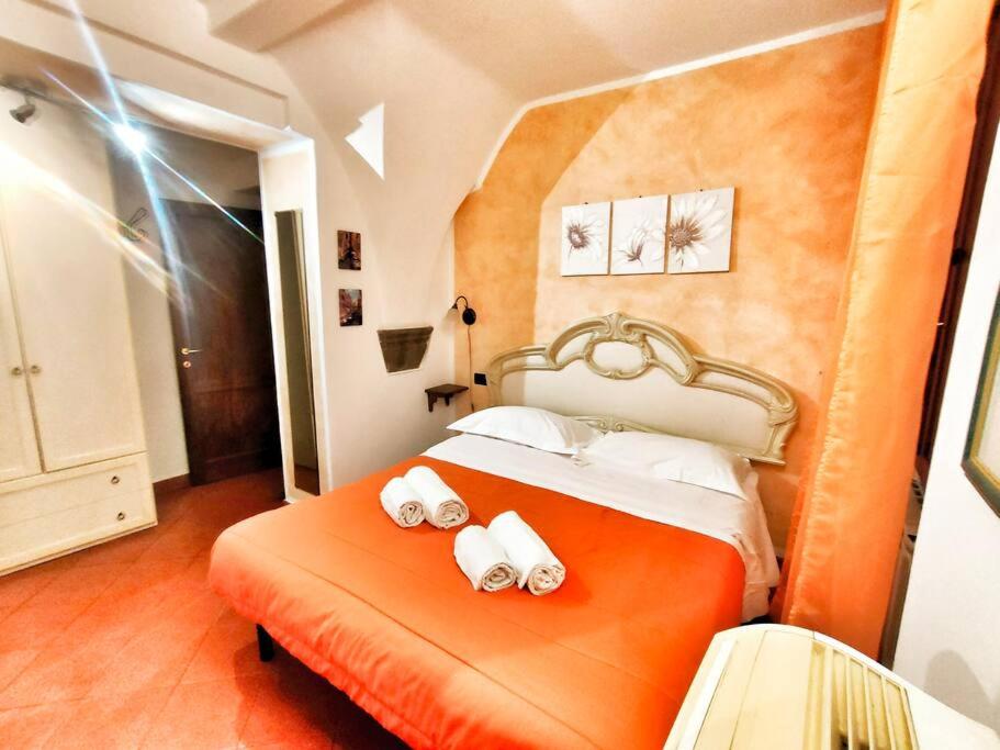 1 dormitorio con 1 cama naranja y 2 toallas enrolladas en Appartamento Stella in centro a Firenze, en Florencia