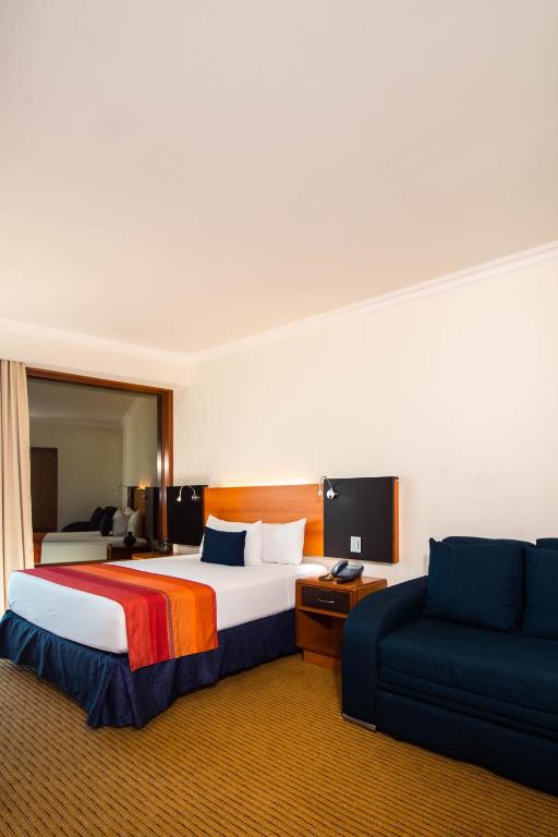 Postel nebo postele na pokoji v ubytování Hotel Guadalajara Plaza Expo