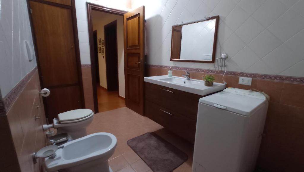 łazienka z toaletą, umywalką i lustrem w obiekcie Villa Italia w mieście Tarent