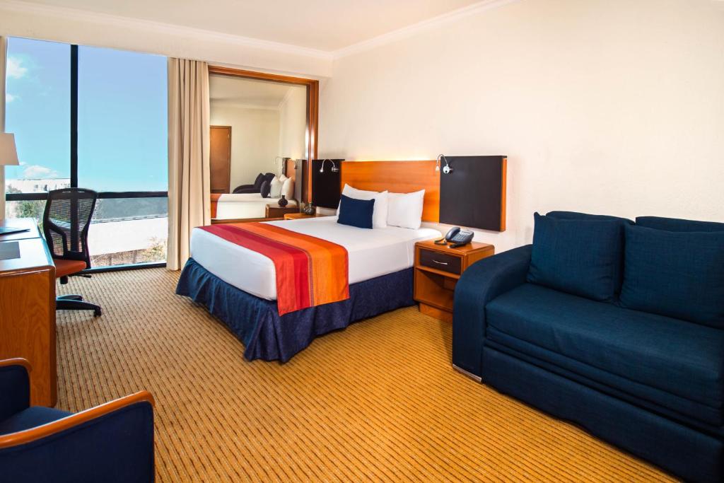 Postel nebo postele na pokoji v ubytování Hotel Guadalajara Plaza Expo