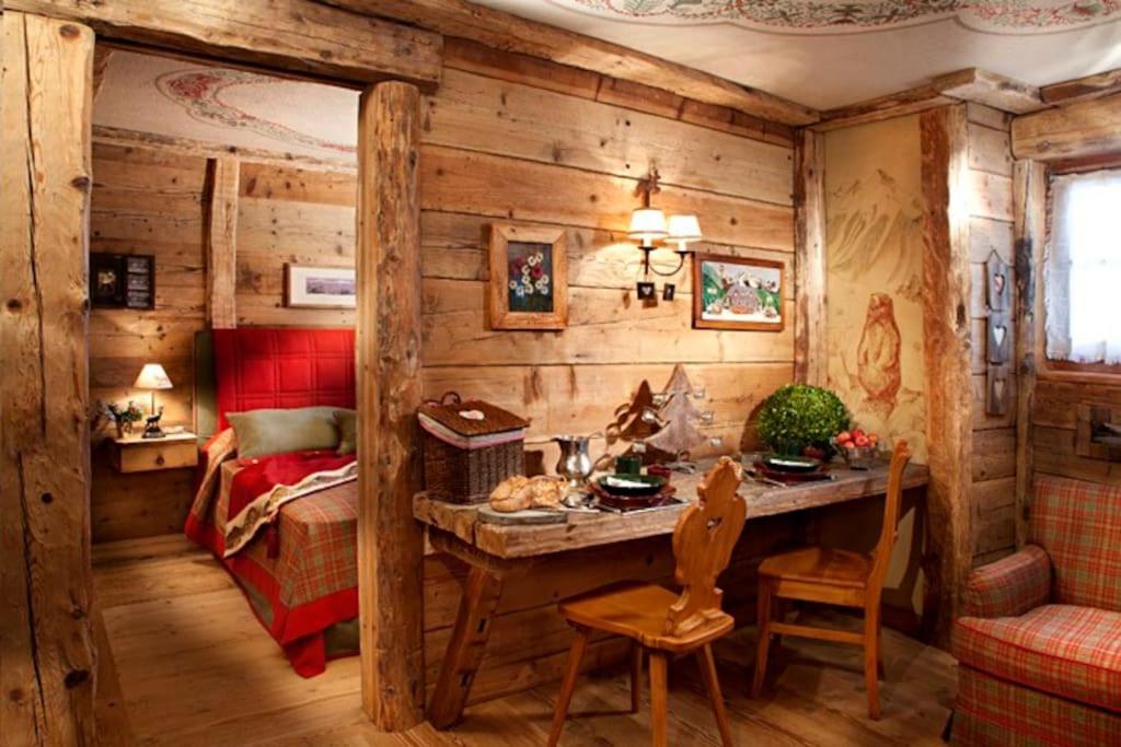 a room with a bedroom with a table and a bed at La Petite in Courmayeur