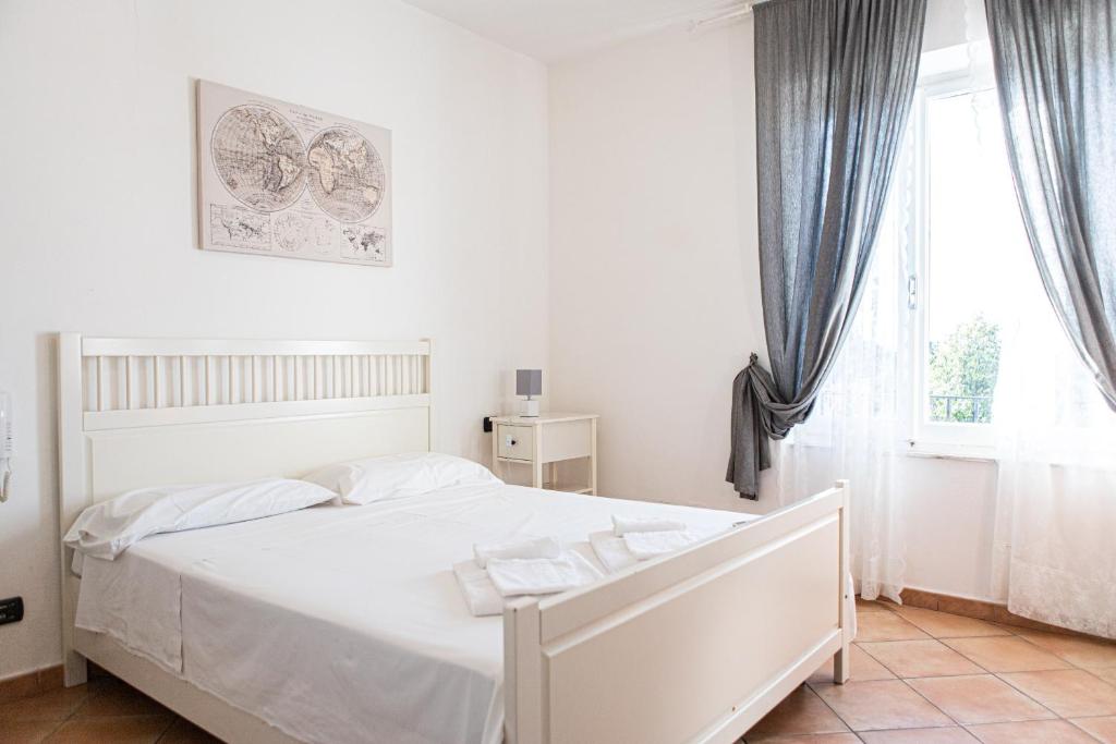 a white bed in a bedroom with a window at Gambero Nero in Tellaro