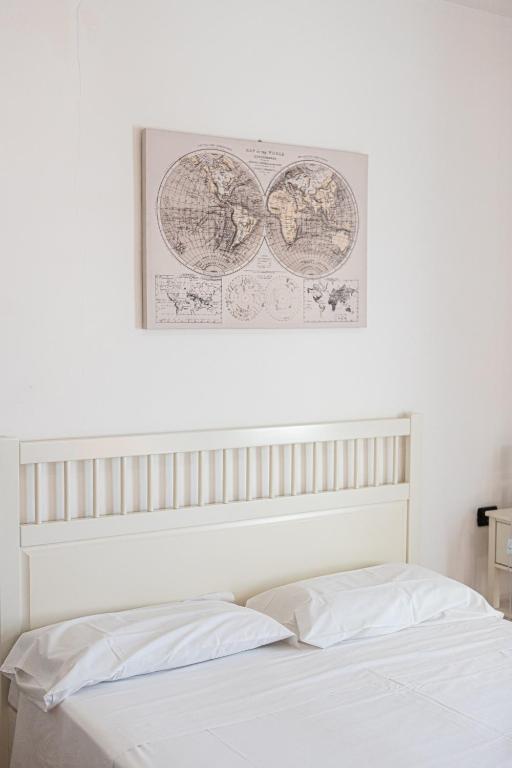 a bedroom with a white bed with a picture on the wall at Gambero Nero in Tellaro