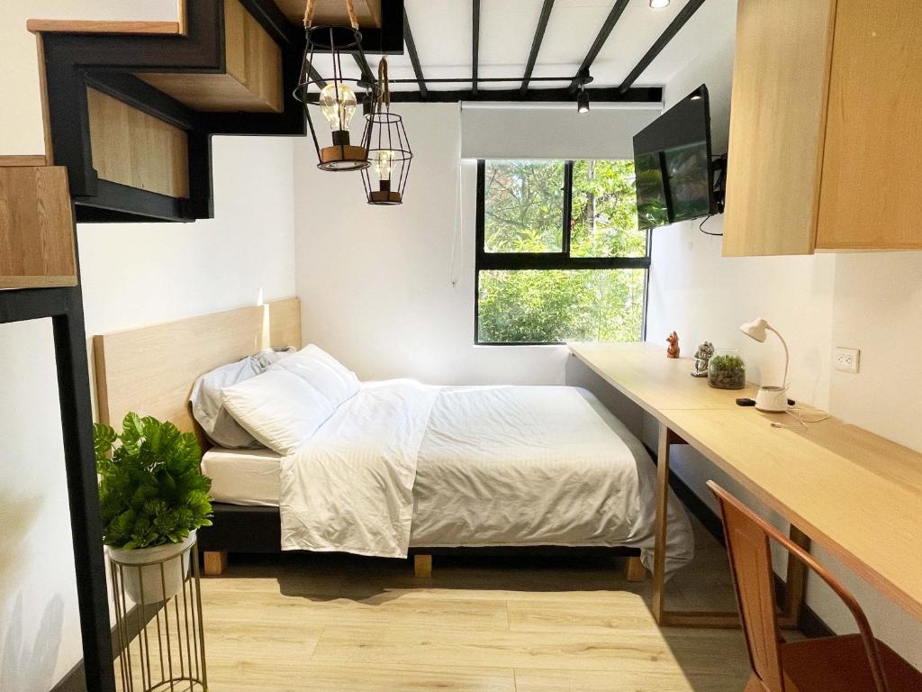 Habitación pequeña con cama y escritorio. en Mini Casa en Poblado Medellín FRN109, en Medellín