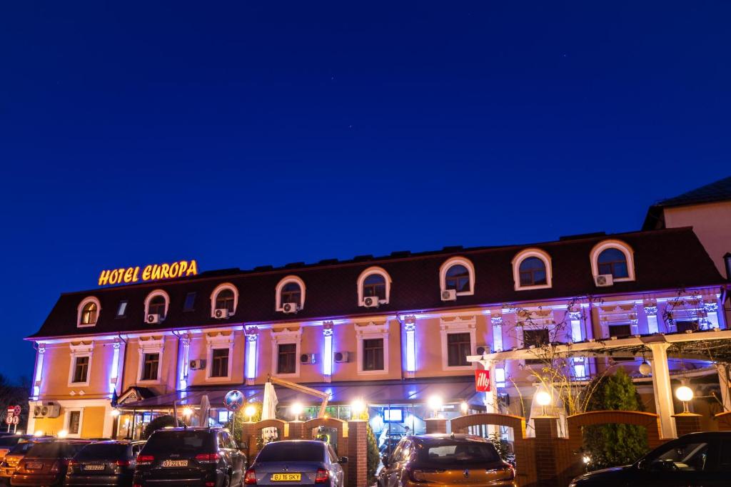 un edificio con luces azules en el lateral. en Hotel Europa, en Târgu Jiu