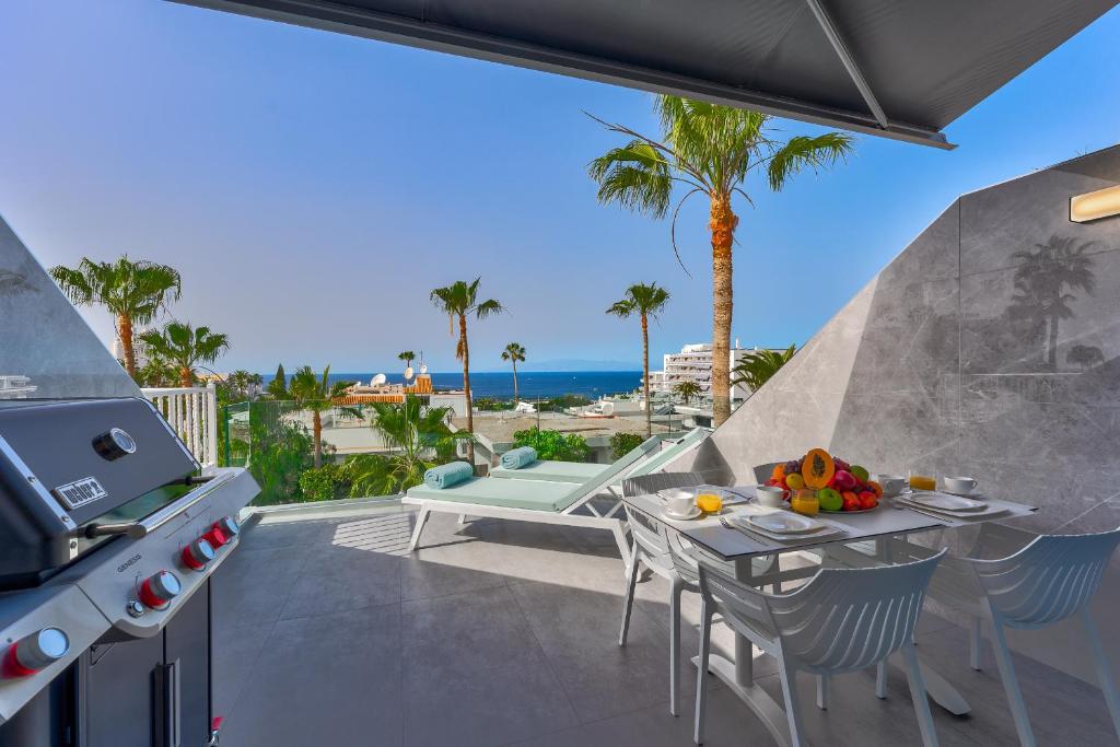un patio con tavolo, grill e oceano di Ocean View Luxury Apartment PH014 ad Adeje
