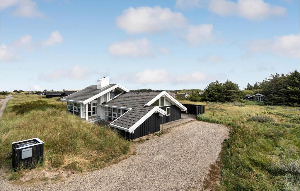 a house on the side of a grassy field at 4 Bedroom Stunning Home In Hirtshals in Hirtshals