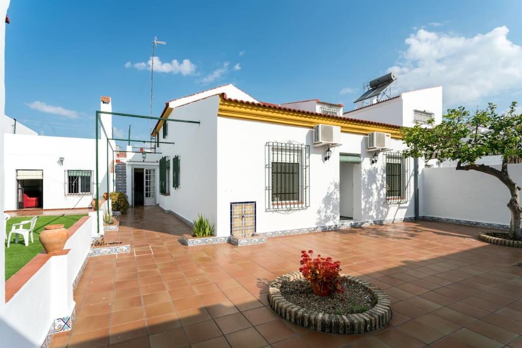 a white house with a courtyard with a tree at La Francesa Doñana in Villamanrique de la Condesa