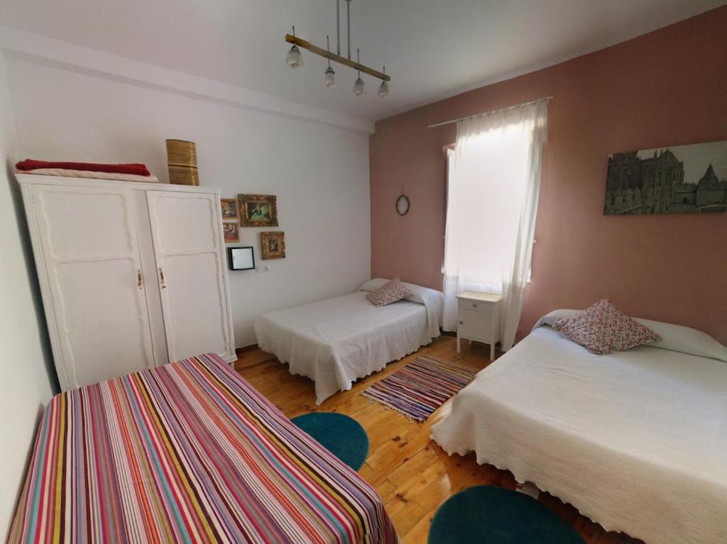 ein kleines Schlafzimmer mit 2 Betten und einem Fenster in der Unterkunft Casa de los Balcones La Bañeza León 