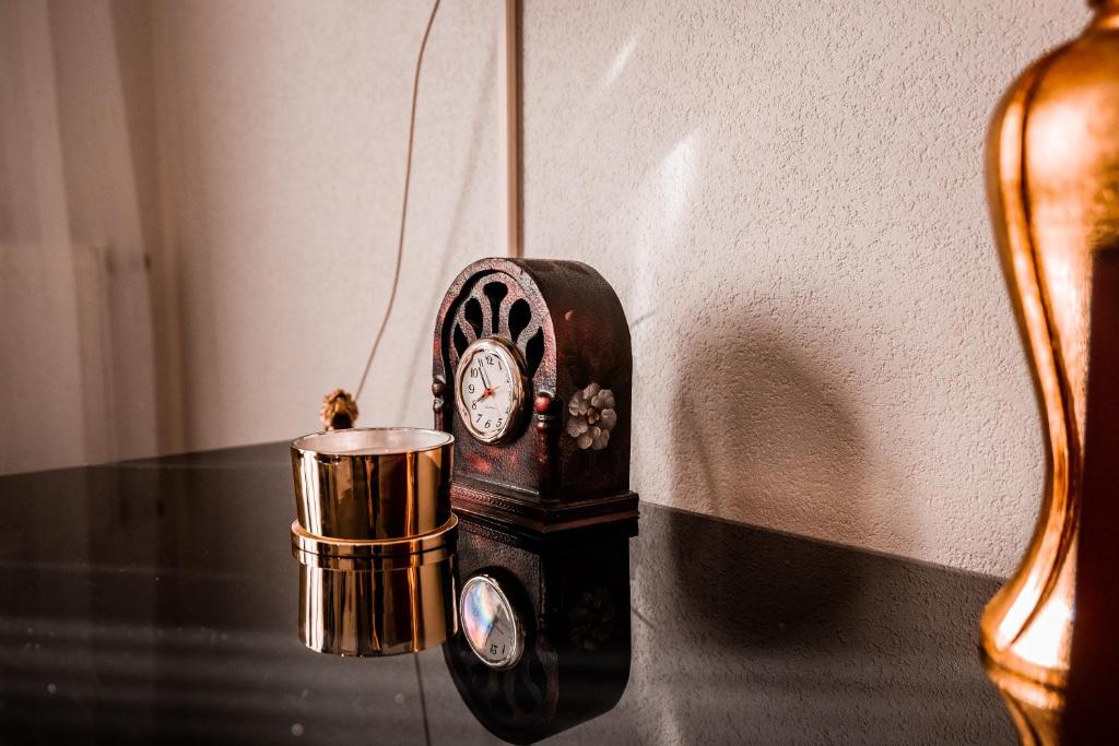 a clock sitting on a table next to a wall at Apartmani Li in Livno