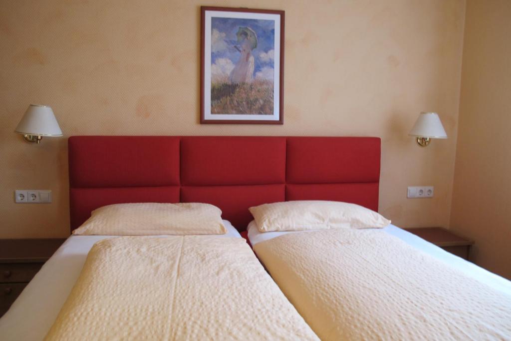 2 camas en una habitación con cabecero rojo en Landgasthof Schwabenpfanne, en Erbach
