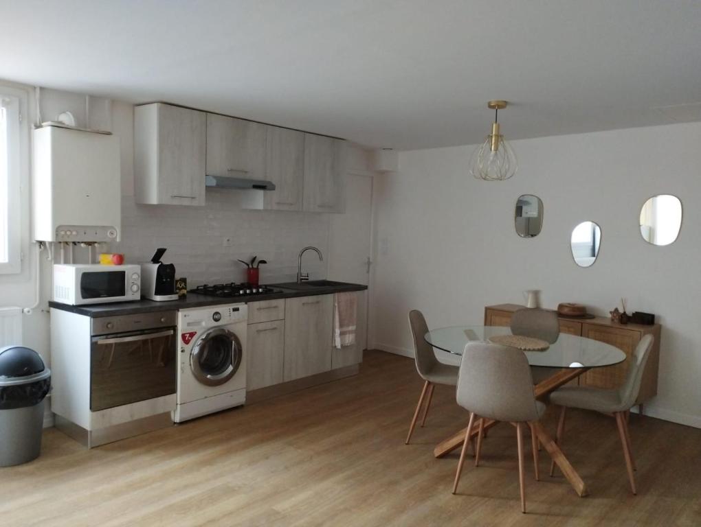 a small kitchen with a table and a table and chairs at Agréable appartement en plein centre ville in Biscarrosse