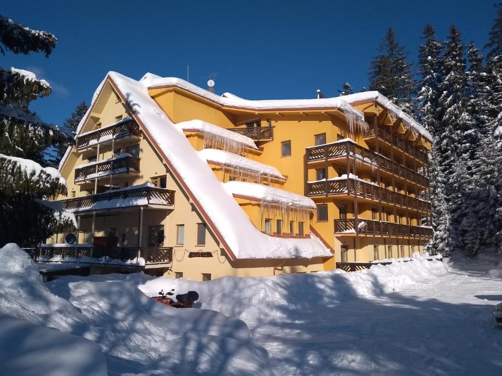 ドノヴァリにあるApartmány Mirka a Maťkoの屋根に雪が積もった黄色い建物
