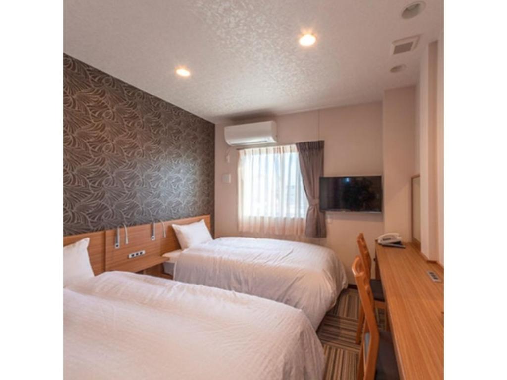 市原市にあるBusiness Hotel Goi Onsen - Vacation STAY 78238vのベッド2台とテレビが備わるホテルルームです。