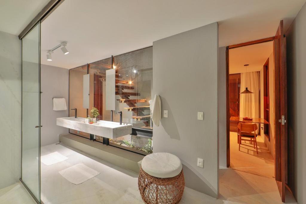 a bathroom with a sink and a glass wall at Villas Taturé in São Miguel dos Milagres