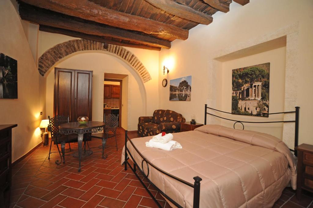 a bedroom with a bed and a table in a room at Rustico La Rosa in Tivoli