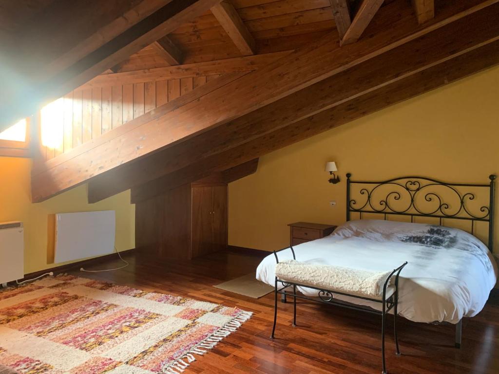 an attic bedroom with a bed and a wooden ceiling at Ático Dúplex en Laspaúles in Laspaúles