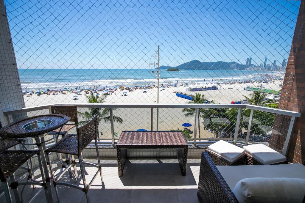 balcón con mesa y sillas y playa en Apartamento Frente Mar, en Balneário Camboriú