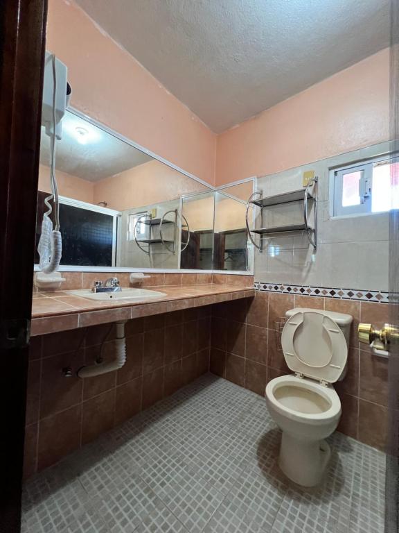 a bathroom with a toilet and a sink and a mirror at Casssa Vlanca Hotel in Palenque
