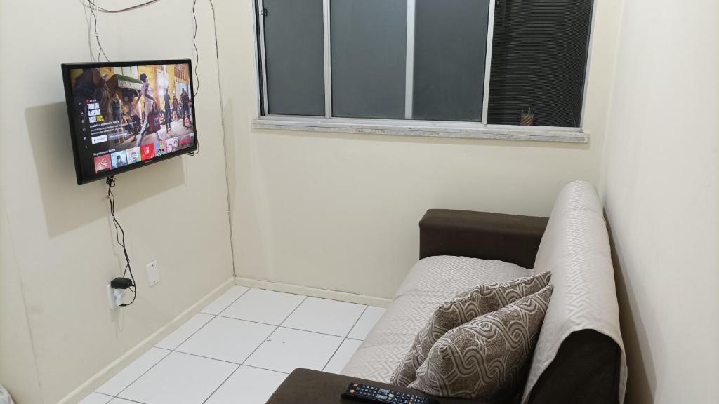 een woonkamer met een bank en een flatscreen-tv bij Apartamento aconchegante próximo à UFS in São Cristóvão