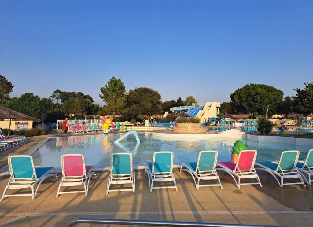 a group of chairs sitting in front of a pool at Mobil home dans un camping **** la réserve / siblu in Gastes