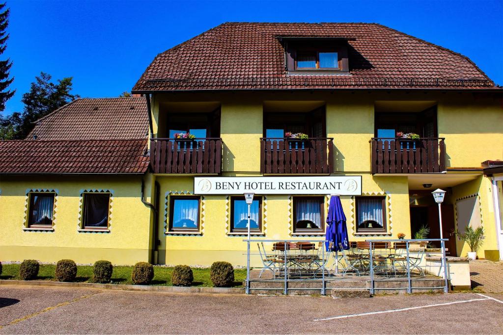 un bâtiment jaune avec un panneau indiquant la baie du restaurant de l'hôtel dans l'établissement Beny Hotel Restaurant, à Bad Bellingen