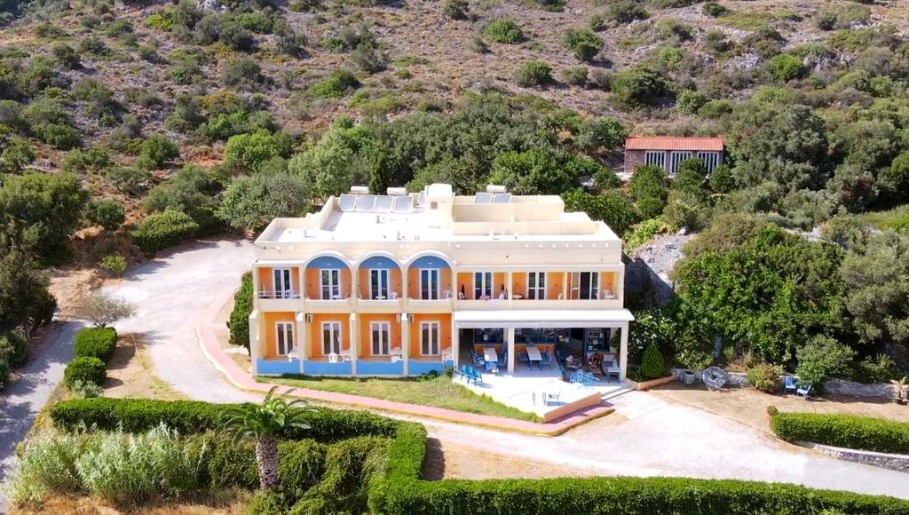 an aerial view of a large yellow house at Phoenix-Hotel in Plakias