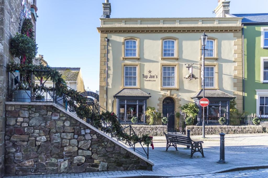 a building with a staircase and a bench in front of it at Top Joe's Townhouse in Narberth