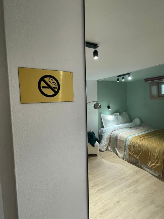 a room with a bed and a no smoking sign on a door at Ministerium underground studio in Thessaloniki